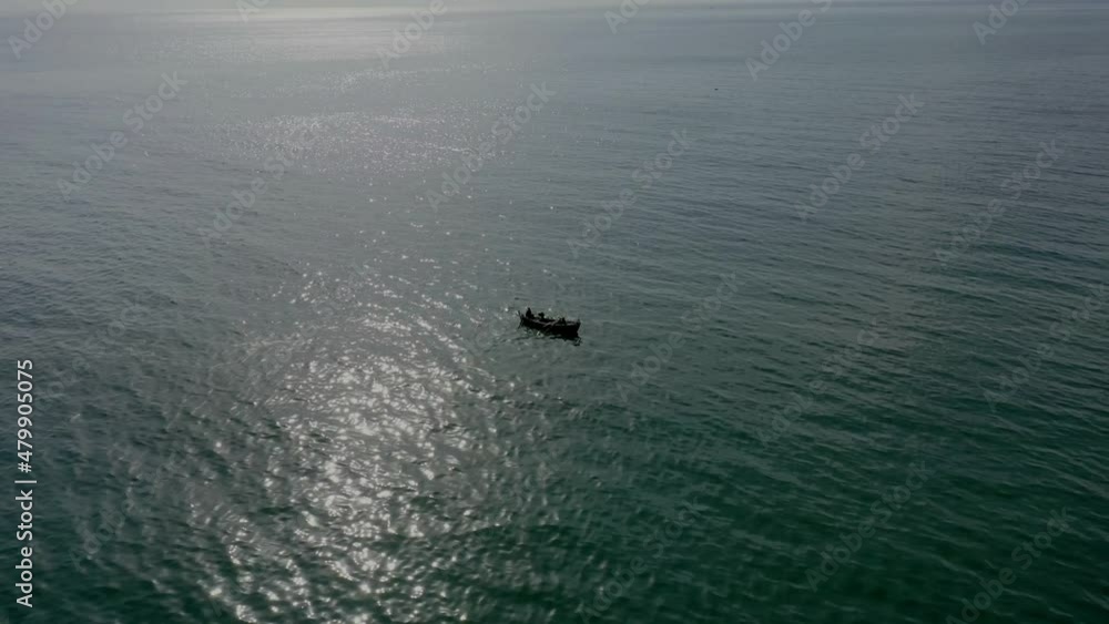 Aerial View Of Silhouette Of Boat Floating In Arabian Sea With Sunlight Reflection Aerial View Of Silhouette Of Boat Floating In Arabian Sea With Sunlight Reflection