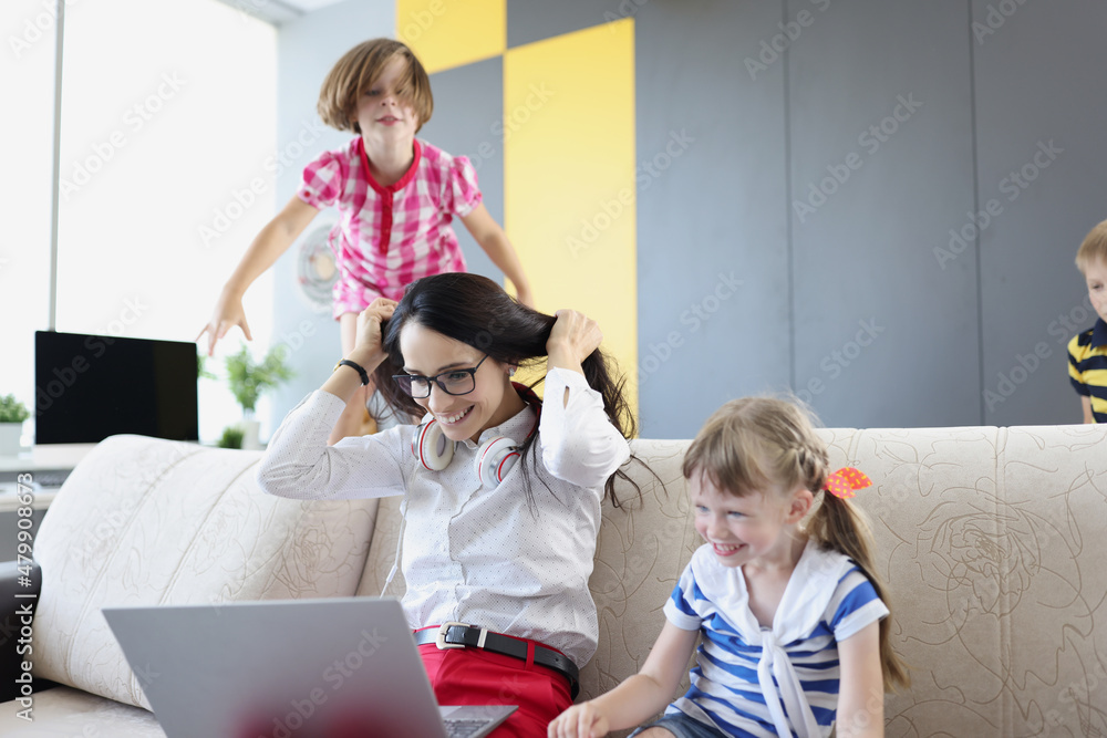 Happy woman working and playing with her kids on couch Happy woman working and playing with her kids on couch