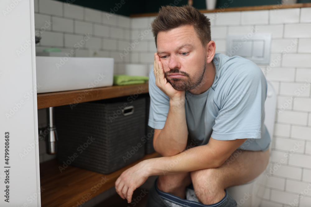 Bored man on toilet seat dream about something, fulfill natural need Bored man on toilet seat dream about something, fulfill natural need