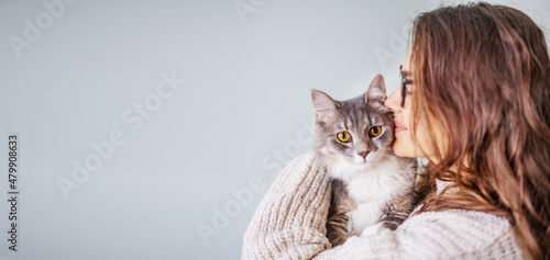 Photography Young cheerful curly girl woman holding a beautiful gray fluffy cat in her arms