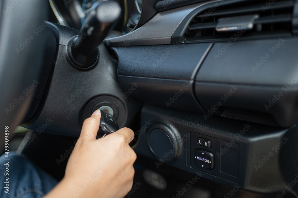 Women's hand turns the key to the car. Hands of the girl to take the keys to start the car engine. Key to start the car engine Women's hand turns the key to the car. Hands of the girl to take the keys to start the car engine. Key to start the car engine