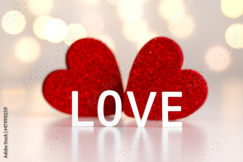 Quadro su tela love - a word of white letters on a background of two red hearts and light gray