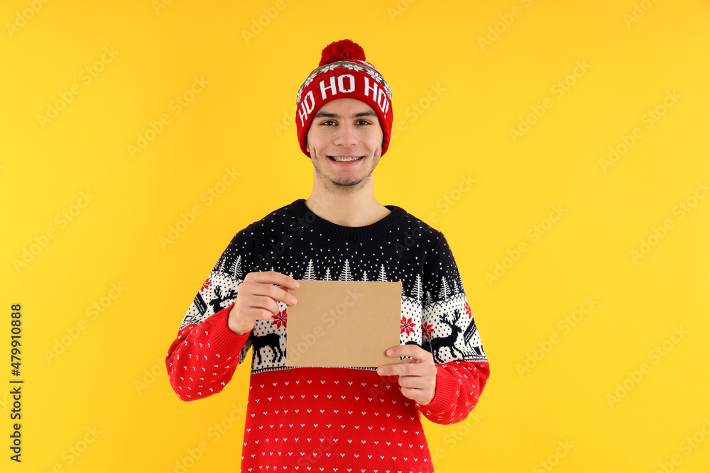 Guy in Christmas sweater with space for text on yellow background