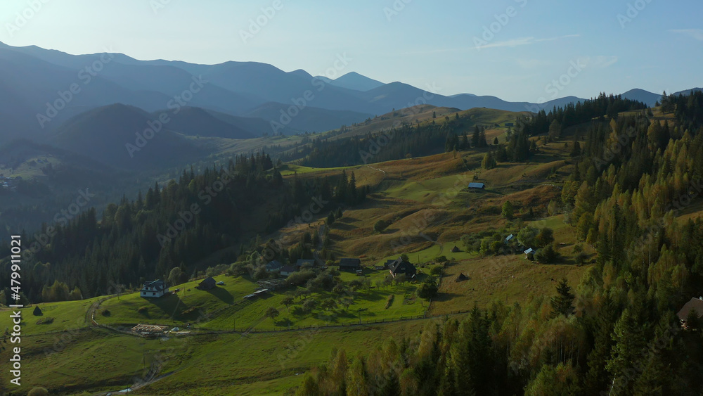 Obraz premium Lonely buildings mountain valley view beautiful green rocky peaks sky background