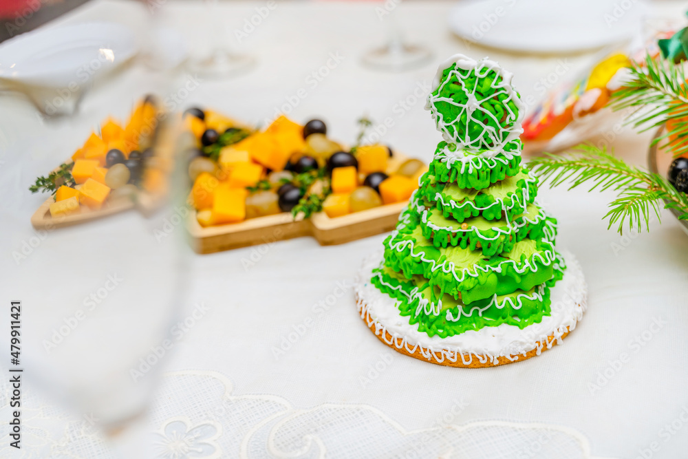 Gingerbread in the form of a Christmas tree with green glaze on a New Year's table 