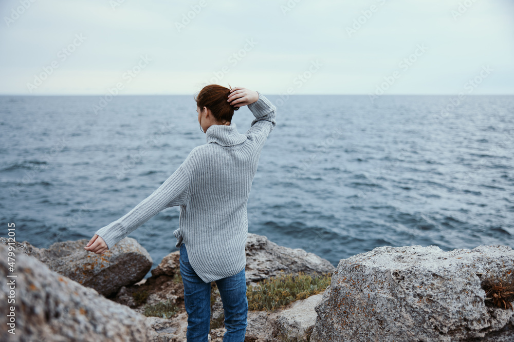 woman sweaters cloudy sea admiring nature Lifestyle back view woman sweaters cloudy sea admiring nature Lifestyle back view