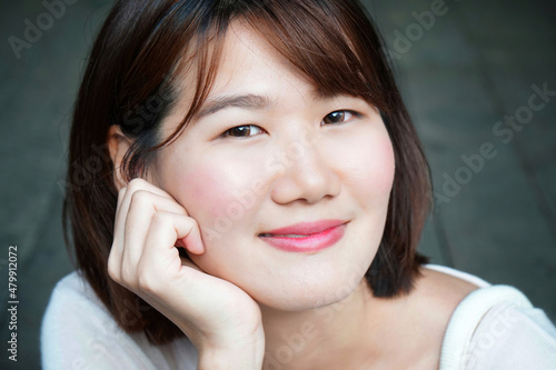 Close up on face of young asian woman in dress up in earth tone color. Minimal portrait and beauty fashion.
