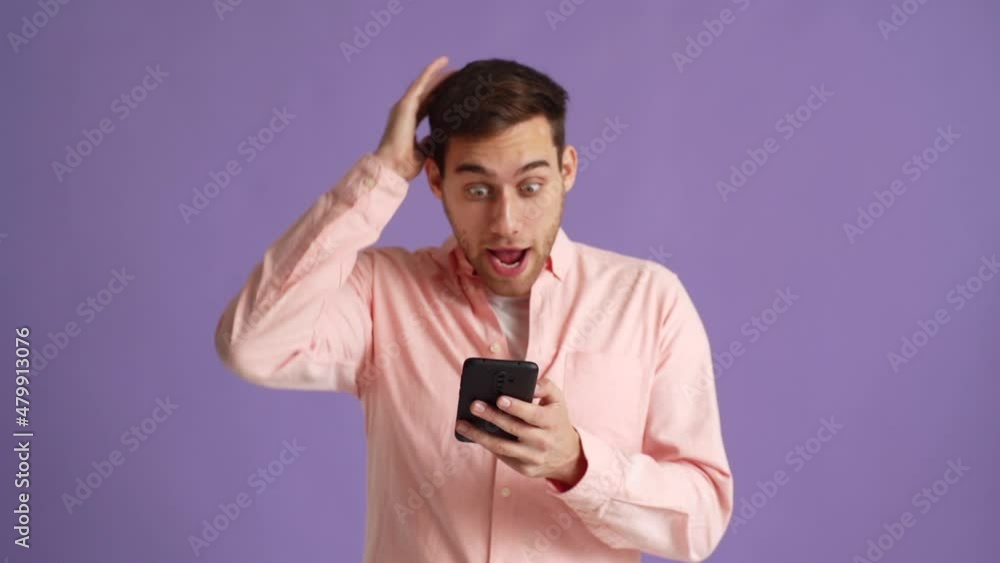 Studio portrait of surprised excited young man screaming during using mobile cell phone just found out great big win news, doing winner gesture say yes on pink isolated background, slow motion. Studio portrait of surprised excited young man screaming during using mobile cell phone just found out great big win news, doing winner gesture say yes on pink isolated background, slow motion.