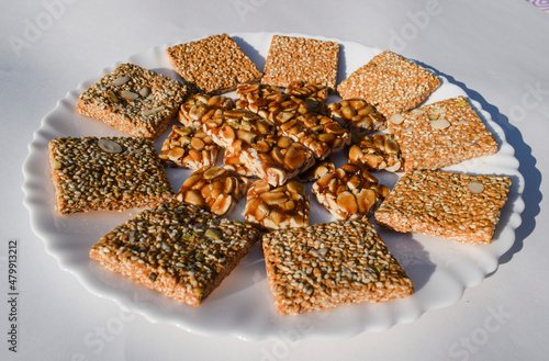 Tasty Indian sesame brittles and Peanut jaggery candy bars known as Til chikki and Peanut or shenga singhdana chikki decorated arranged served during winters sankranti uttarayan pongal festival food photo