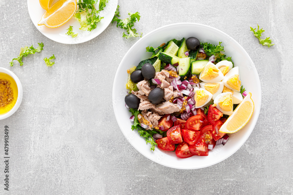 Tuna and fresh vegetable salad of tomato, cucumber, olives, onion, lettuce and boiled egg, top view Tuna and fresh vegetable salad of tomato, cucumber, olives, onion, lettuce and boiled egg, top view