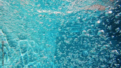 4K Cinematic slow-motion underwater footage. Lots of air bubbles float in the blue water of the pool. photo