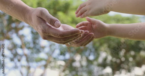 4K Video slow motion mom and daughter holding hand with green park background. Concept of family connection of mother and kids.