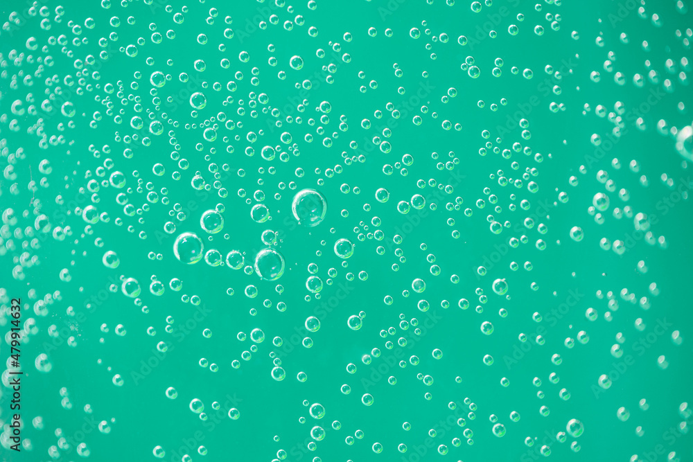 Water drops on glass on green background. Artistic macro under natural light, air drops on glass background
