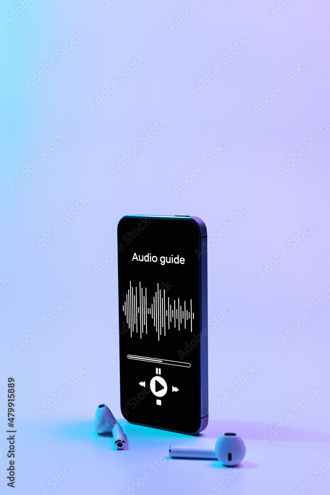 Audio tour guide online app on mobile smartphone screen with music headphones. Digital library with audiobooks, audioguide, courses on neon background.