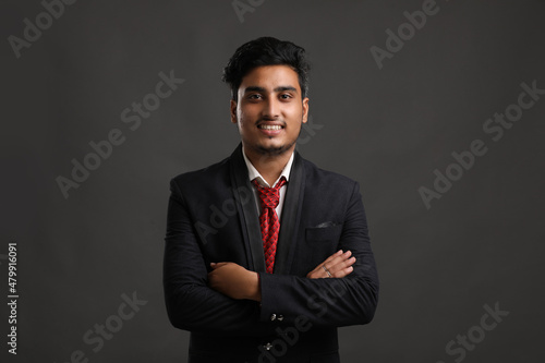 Young indian business man showing expression on dark background.