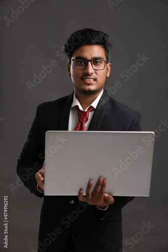 Young indian banker or officer using laptop
