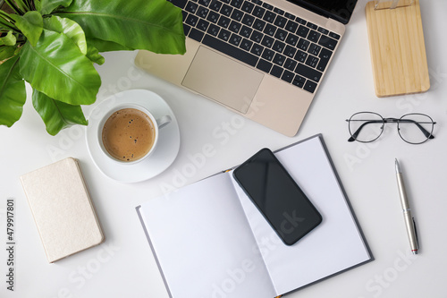 Office stationery, laptop and smartphone on white table, flat lay