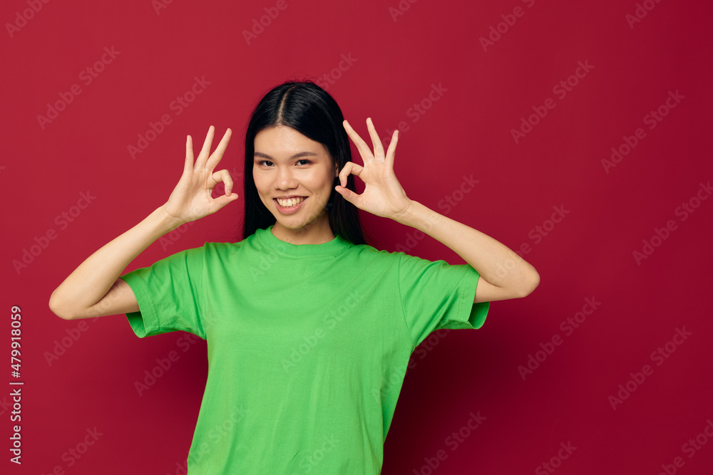 Charming young Asian woman green t-shirt gestures with his hands studio model unaltered Charming young Asian woman green t-shirt gestures with his hands studio model unaltered