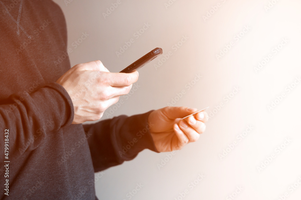Man holds bank card and mobile phone in his hands. Man holds bank card and mobile phone in his hands.