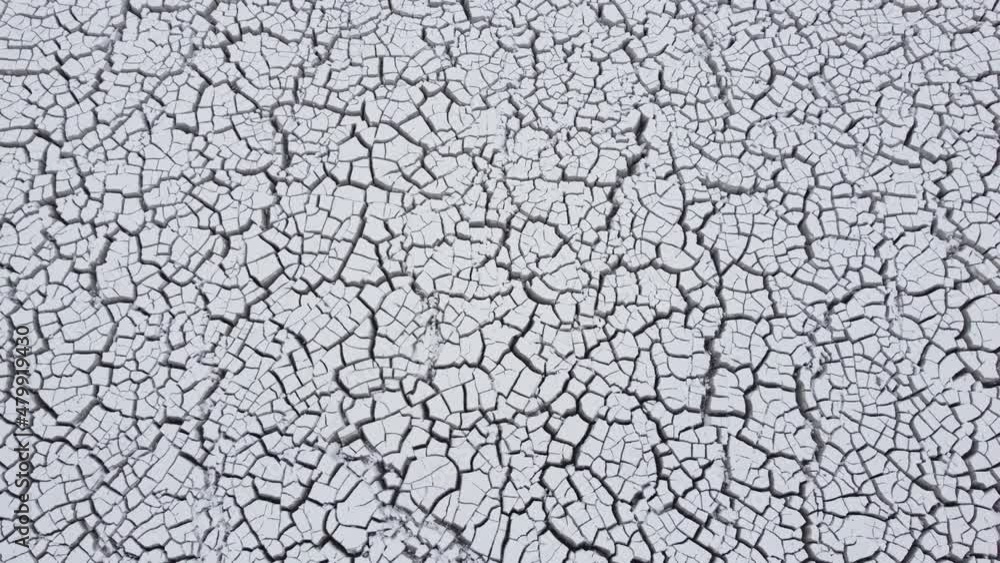 Cracked white surface. Crack surface on land. Dry desert cracks. Cracked soil ground in nature. Aerial drone view of material in tailings reservoir. Land contamination. Cracked white surface. Crack surface on land. Dry desert cracks. Cracked soil ground in nature. Aerial drone view of material in tailings reservoir. Land contamination.