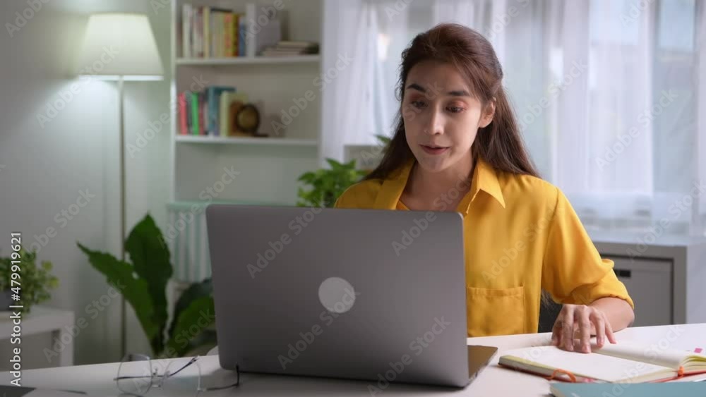 Young Asian businesswoman sitting at home working on laptop computer. Asian woman studying online using laptop surfing information or shopping in internet store Young Asian businesswoman sitting at home working on laptop computer. Asian woman studying online using laptop surfing information or shopping in internet store