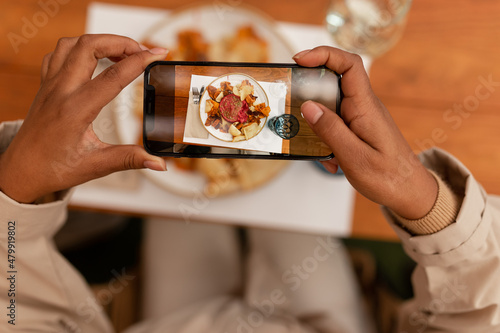Blogger taking a picture of her food in a restaurant