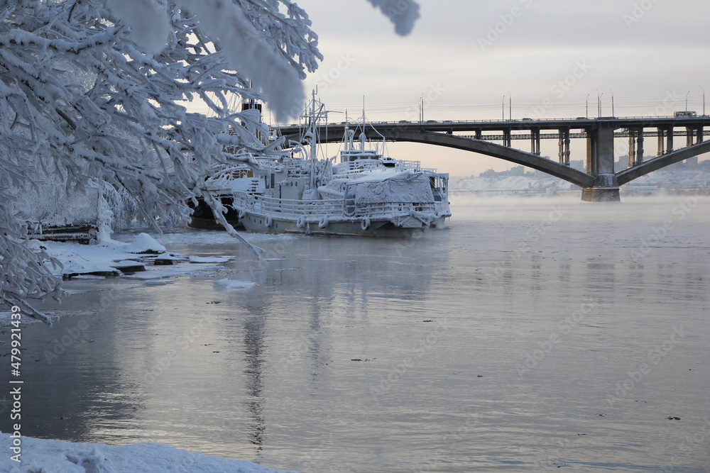 Snow-covered ships wintering on the river. Frost. Severe frost.