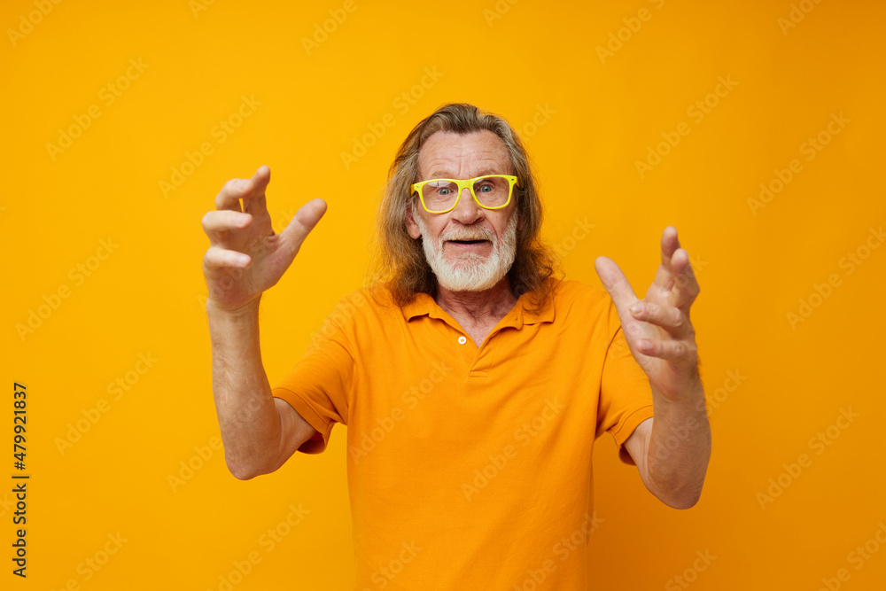 Naklejka premium Senior grey-haired man hand gestures emotions yellow glasses monochrome shot