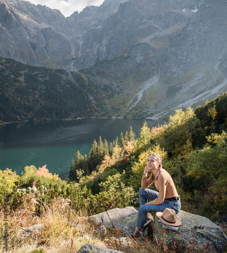 Young woman on a hiking trip sitting on a rock