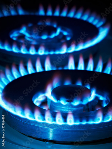 Closeup shot of blue fire from domestic kitchen stove top. Gas cooker with burning flames of propane gas. Industrial resources and economy concept.