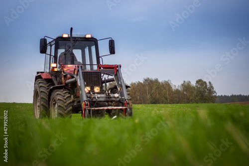 Tractor on a green field on a cloudy day