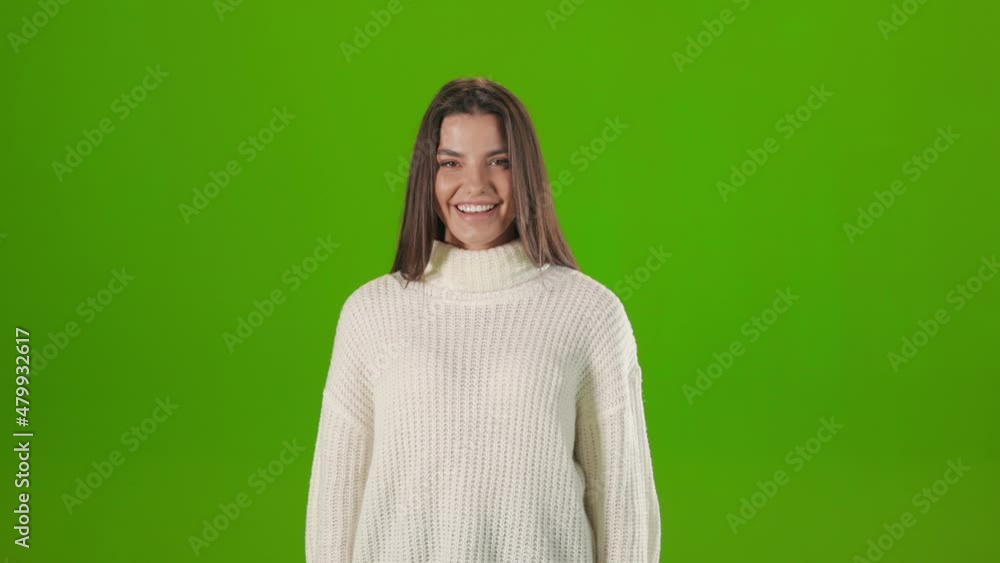 Adorable dark haired woman in casual outfit with sincere smile on face posing over green background. Young lady with positive emotions in studio. Adorable dark haired woman in casual outfit with sincere smile on face posing over green background. Young lady with positive emotions in studio.