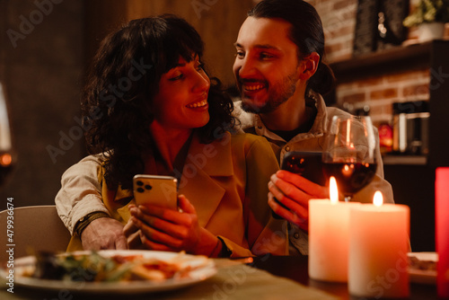 White couple using mobile phones during romantic date at home