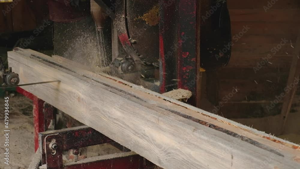The process of processing and sawing pine boards on an old sawmill ...