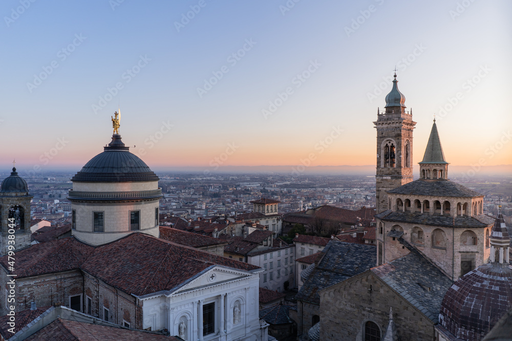 Cityscape of Bergamo Upper city with the dome and the Basiica at sunset.