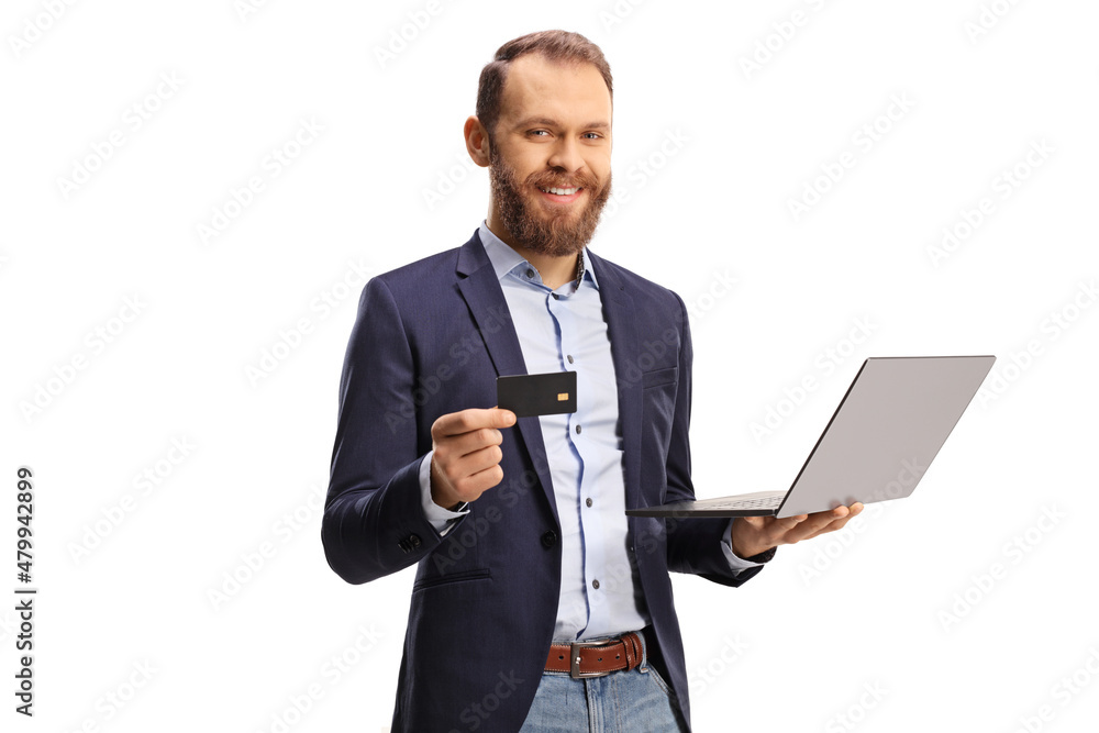 Professional man holding a credit card and a laptop computer and smiling at camera Professional man holding a credit card and a laptop computer and smiling at camera