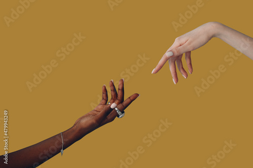 Caucasian white and African American black hand reaching out to each other on brown background. World Humanitarian Day photo