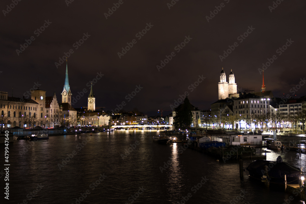 Cityscape of the old town of Zürich with protestant churches and river Limmat in the foreground on a rainy and snowy winter Friday night. Photo taken January 7th, 2022, Zurich, Switzerland.