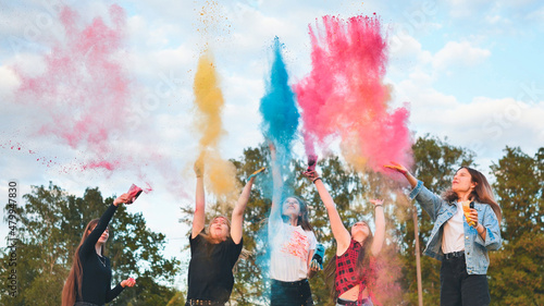 Cheerful girls toss up multi-colored powder. Holi holiday. © Довидович Михаил