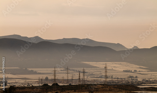 Landscape of plastic greenhouses and transmission towers against mountains in Almeria, spain