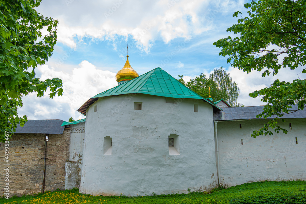 View of beautiful buildings and orthodox churches ancient Pskov-Pechersky monastery. Fortress wall and tower. Pechory, Pskov, Russia.