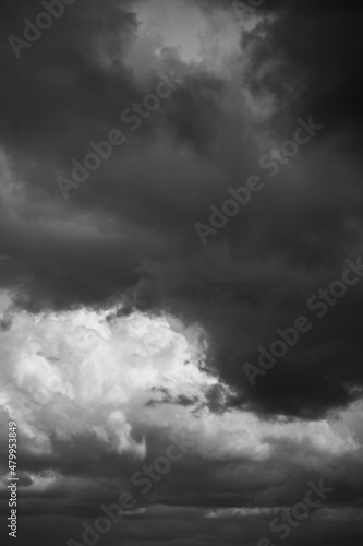 Epic Dramatic storm sky with dark grey black and white cumulus rainy clouds background texture. Black and white photo