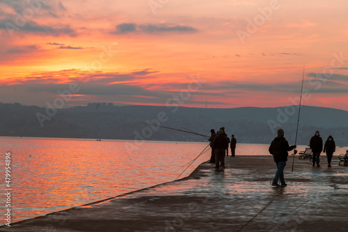 fisherman fishes on Bosphorus Istanbul on a Foggy sunrise. Rainy clouds and dark weather