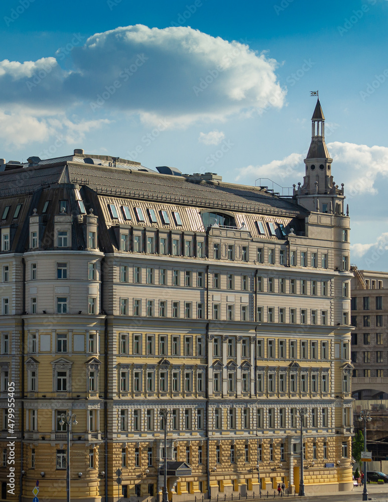 Moscow, Russia - June 16, 2019: View of Hotel Baltschug Kempinski  in rays of setting sun. Close-up of oldest Moscow building on Raushskaya Embankment from floating bridge.