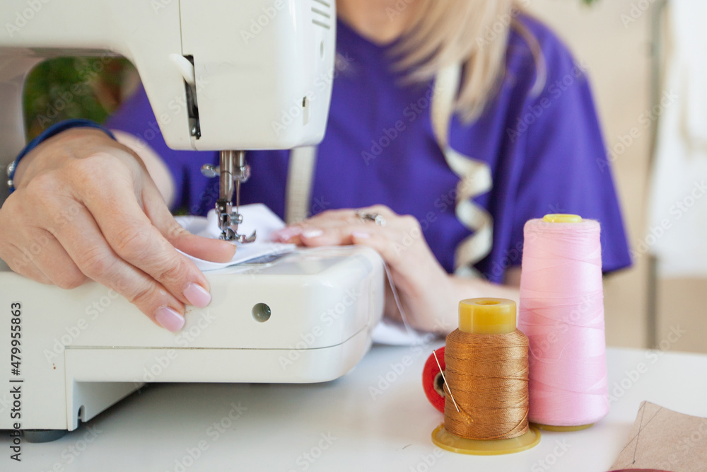 a woman sews on a sewing machine