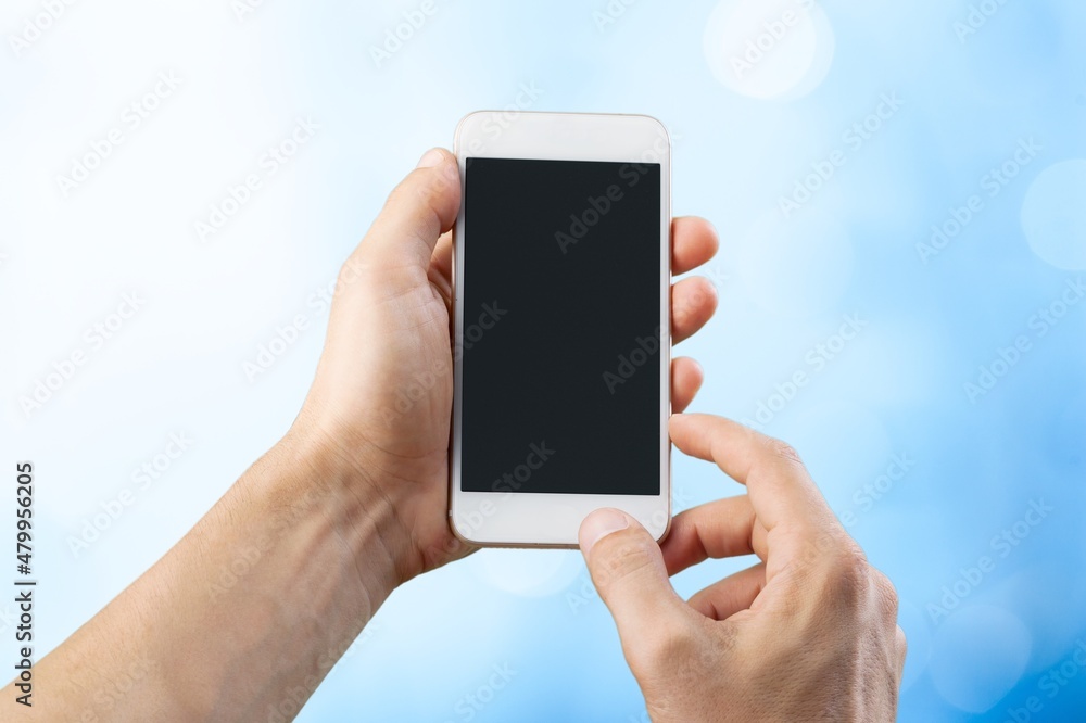 Human hands showing smartphone against background.