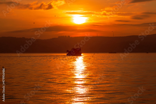 big ship with sunset. orange sky and clouds © Birol