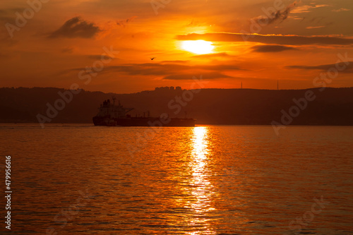 big ship with sunset. orange sky and clouds