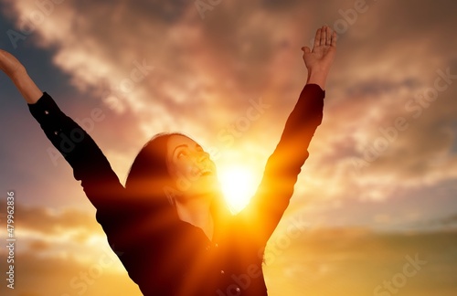 Carta da parati Young woman looking up feeling energized by the warm rays and sky