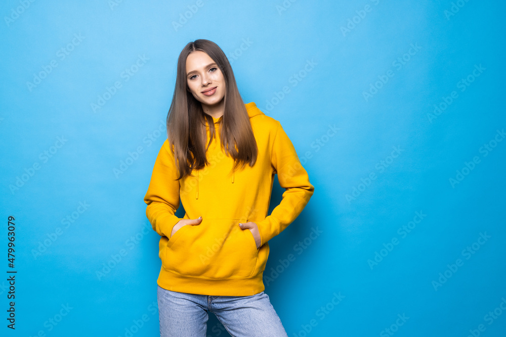 Young happy woman smiling and looking at camera isolated over blue background Young happy woman smiling and looking at camera isolated over blue background